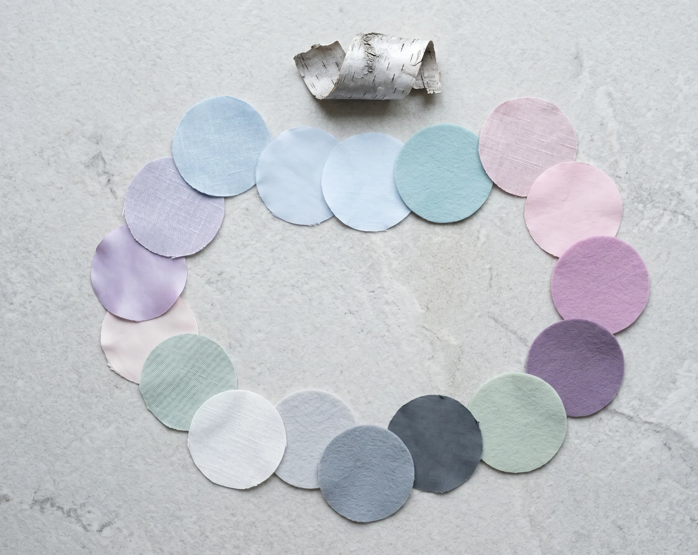 Complete Light Summer color palette shown as sixteen cool-toned, very light fabric swatches arranged in an oval — powder blue, pale lavender, icy pink, cool mint, and silver-grey neutrals — the lightest, most Spring-adjacent palette in the Summer family